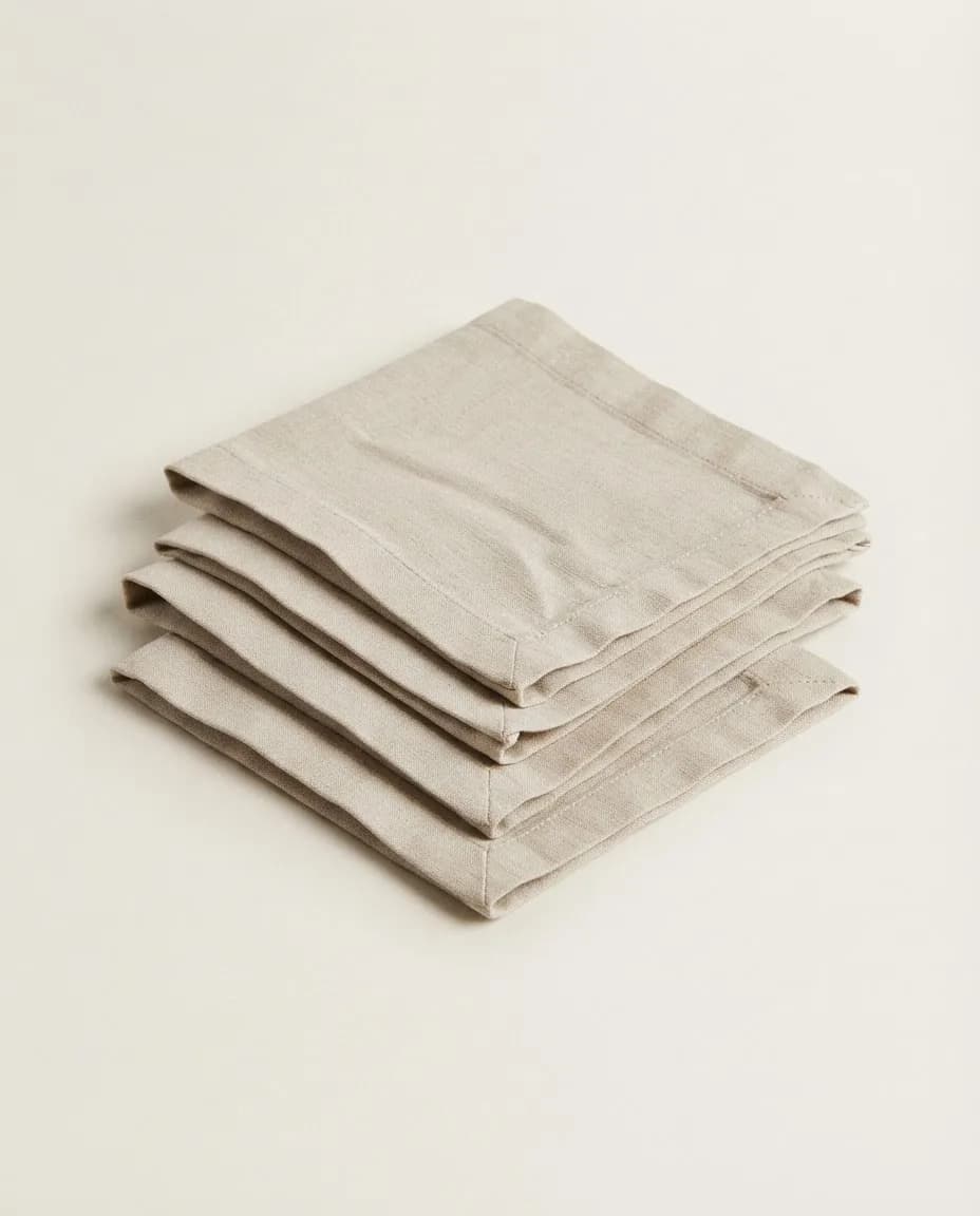 Stack of four folded oatmeal linen napkins